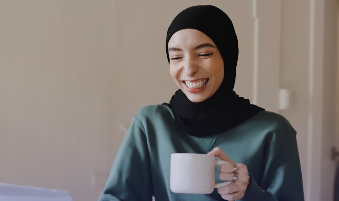woman smiling wide with mug
